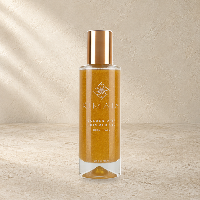 KIMAIA Golden Drip Shimmer Oil — hoofdfoto op een lichte natuurlijke achtergrond
