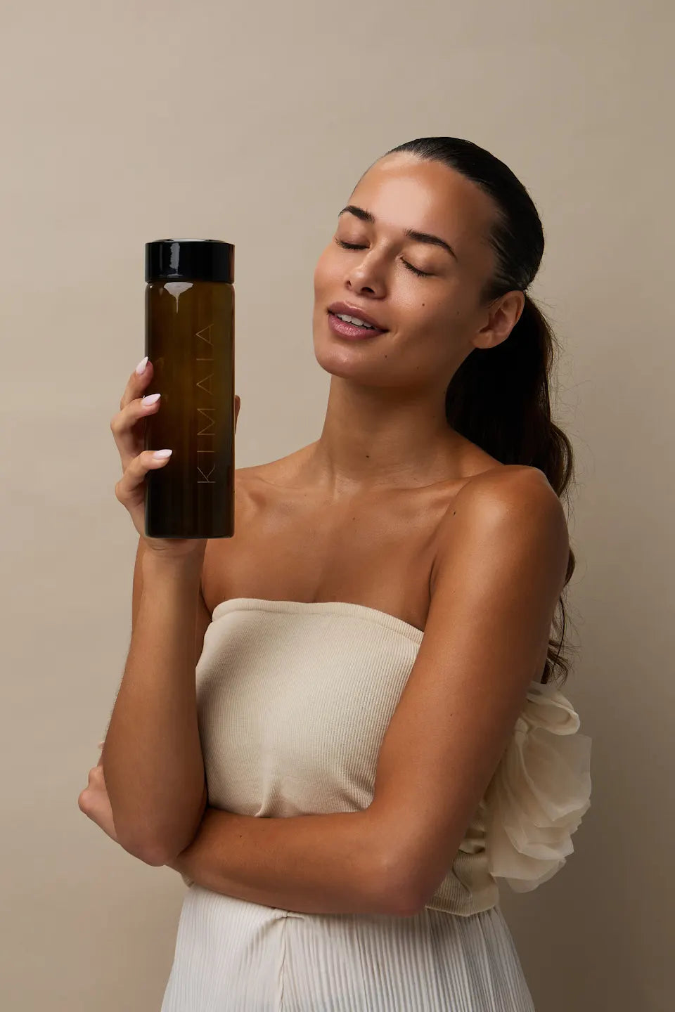 Model met de KIMAIA Water Bottle in warm studiolicht