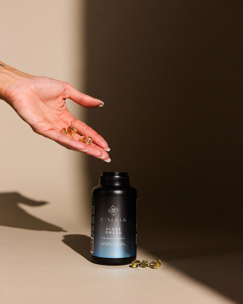Algae Omega met capsules in de hand, gefotografeerd in warm natuurlijk licht.